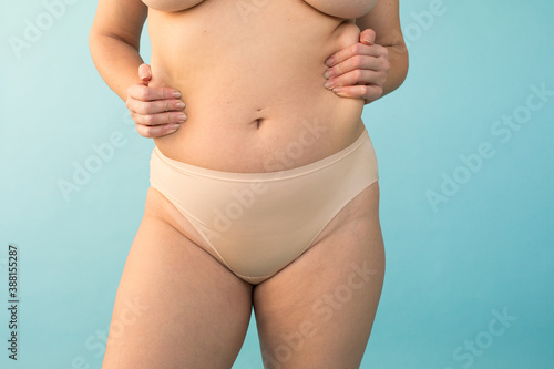 Unrecognizable plus size model kneading body