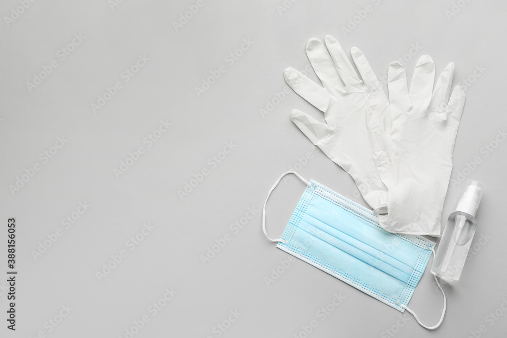 Medical gloves, protective mask and hand sanitizer on grey background, flat lay. Space for text - obrazy, fototapety, plakaty 