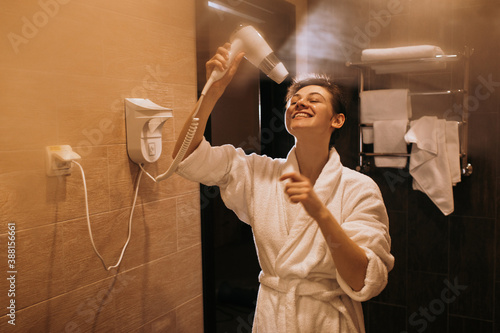 Cheerful woman drying hair after shower