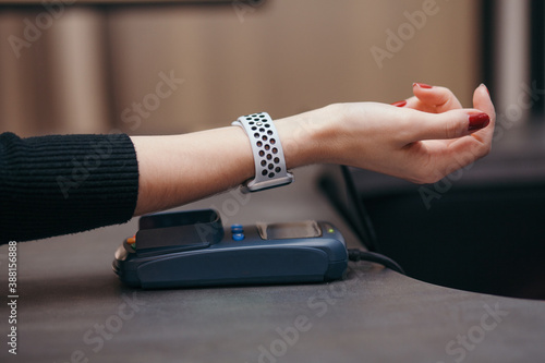 Female customer using smart watch for NFC payment in store photo