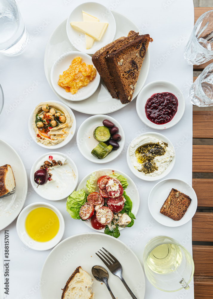 lebanese spread at restaurant with creamy hummus, eggs, green shakshuka, labaneh, zaatar, jam and bread lebanese spread at restaurant with creamy hummus, eggs, green shakshuka, labaneh, zaatar, jam and bread