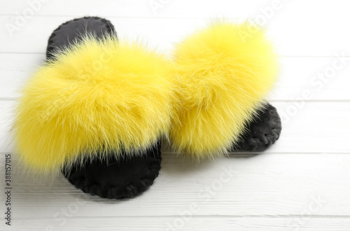 Pair of soft slippers on white wooden background, closeup