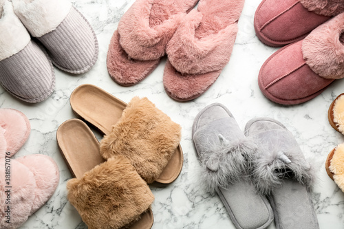 Cuadro en lienzo Many different soft slippers on white marble background, flat lay