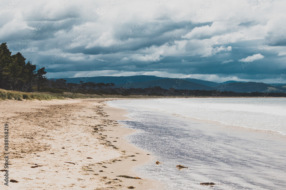 beautiful view of Seven Mile Beach just outside the city of Hobart in Tasmania, Australia on an overcast day with stormy clouds