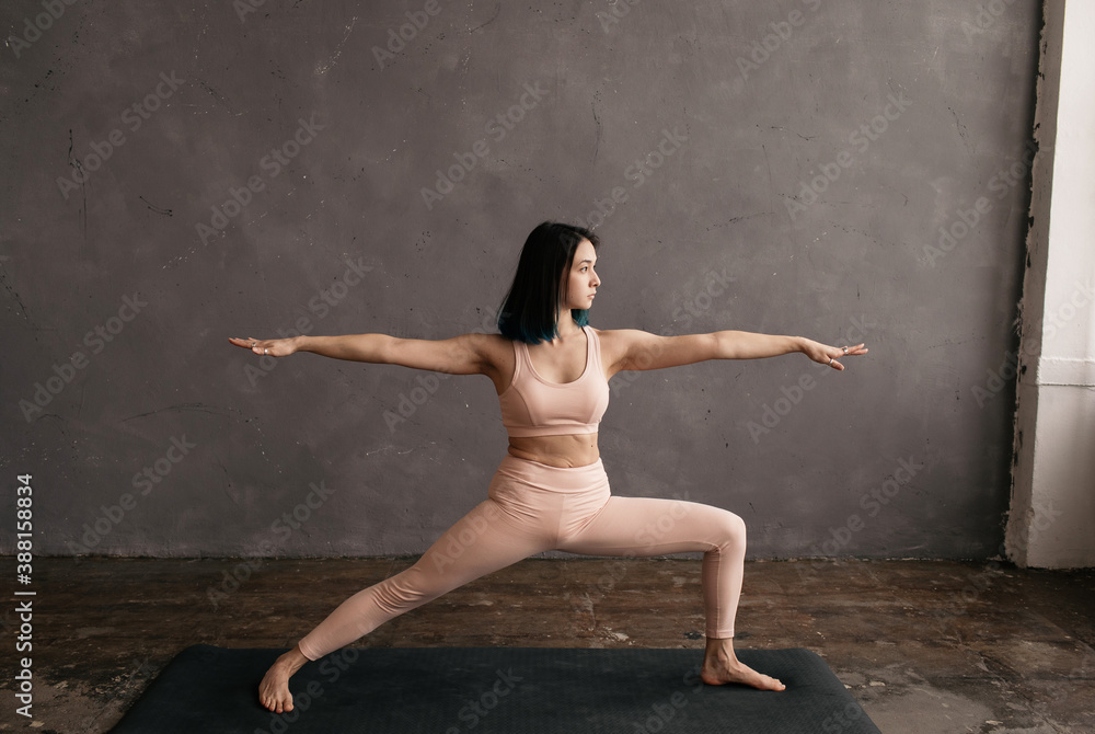 Determined ethnic woman standing in Warrior pose Determined ethnic woman standing in Warrior pose