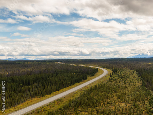 Beautiful View of Scenic Curvy Road from Above surrounded by Forest, Land and Trees in Canadian Nature. Aerial Drone Shot. Taken near Alaska Highway, Yukon, Canada.