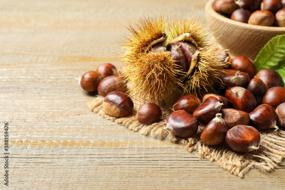 Fresh sweet edible chestnuts on wooden table Fresh sweet edible chestnuts on wooden table