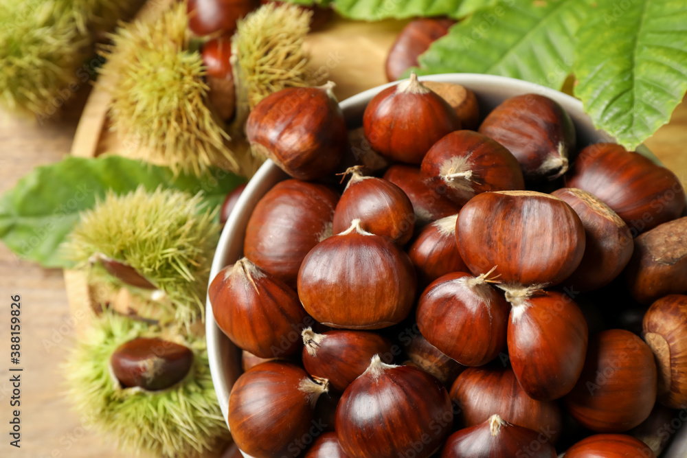 Fresh sweet edible chestnuts in bowl on table, top view Fresh sweet edible chestnuts in bowl on table, top view
