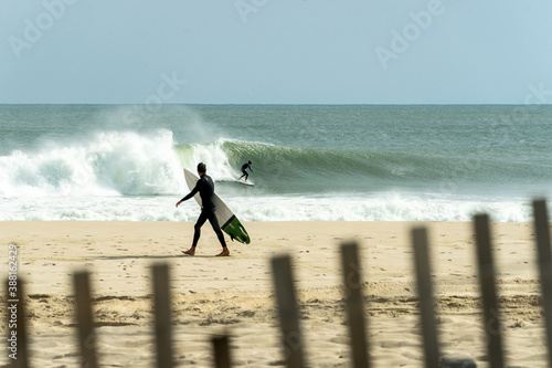 Photography A surfer enjoys a wave while another surfer watches from the shore