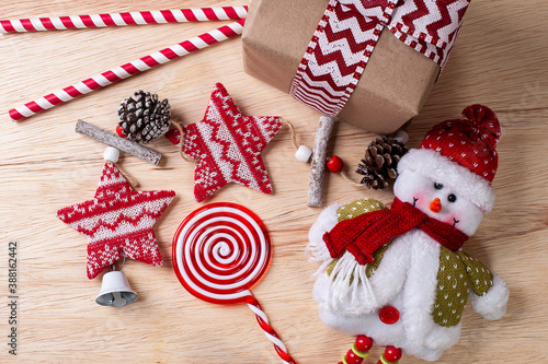 Christmas composition on wooden background with ribbons and gifts and snowman. Top view. Copy space