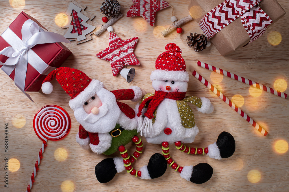 Christmas composition on wooden background with ribbons and gifts, Santa Claus and snowman. Bokeh lights. Top view. Copy space