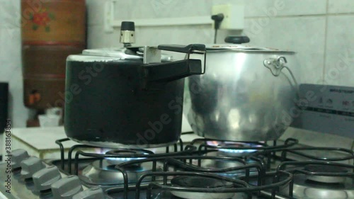 A pressure cooker and a cauldron on a stove