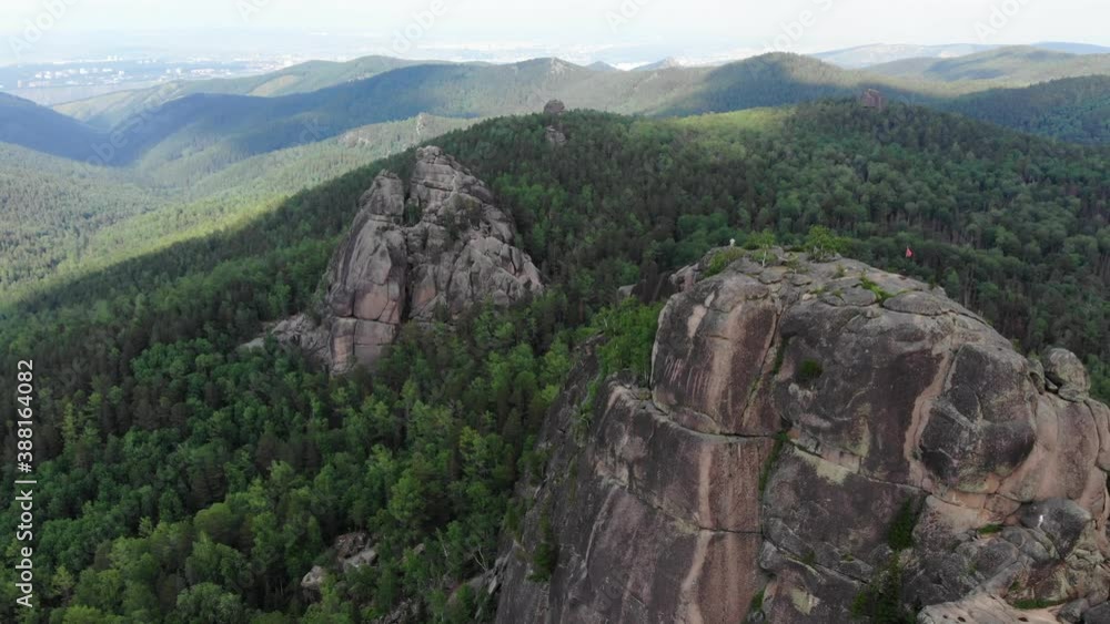 Rocks in the forest. Mountains in the taiga. Krasnoyarsk Pillars National Reserve Park. A very long shot. Aerial view of a drone flying Rocks in the forest. Mountains in the taiga. Krasnoyarsk Pillars National Reserve Park. A very long shot. Aerial view of a drone flying