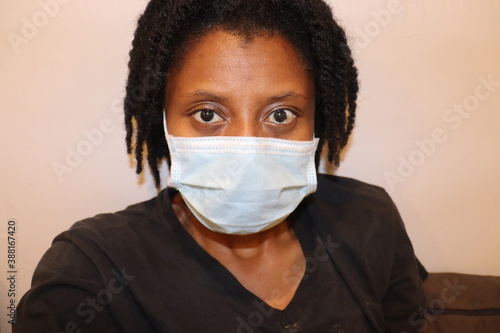 Women wearing blue surgical face mask close up indoors