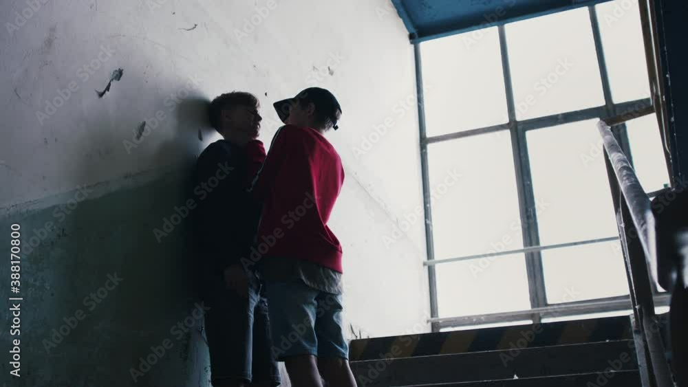 Teenage boy attacked by thug in abandoned building, gang violence and bullying concept. Teenage boy attacked by thug in abandoned building, gang violence and bullying concept.