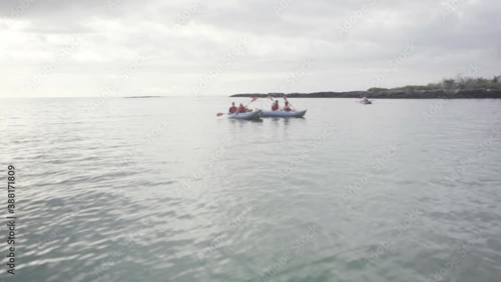 Two kayaks are on the ocean of the Galapagos islands. The tourists are enjoying the view. Two kayaks are on the ocean of the Galapagos islands. The tourists are enjoying the view.