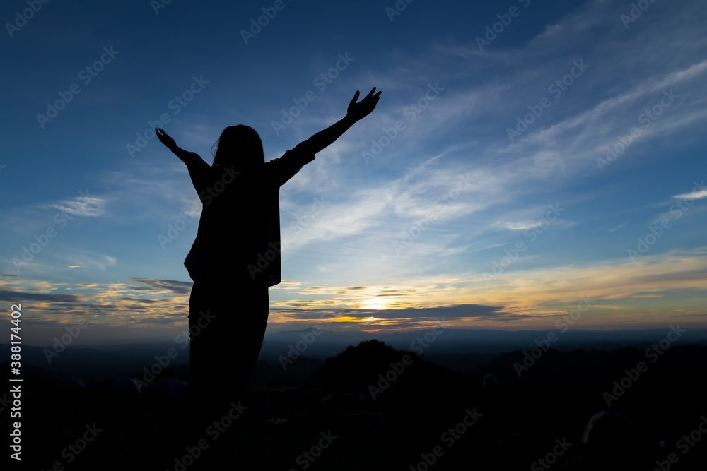 Silhouette of asian woman raise her arms looking at the mountain and enjoy with beautiful nature with freshness and happiness