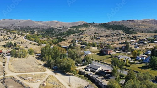 Aerial-Flying over small town in the mountains of Montana under a clear blue autumn sky