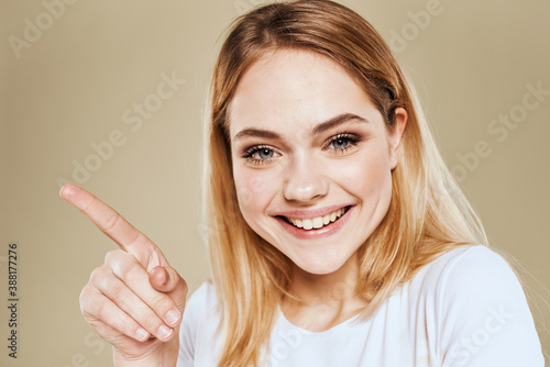 Wallpaper Mural Cheerful blonde gesturing with her hands studio beige background Torontodigital.ca