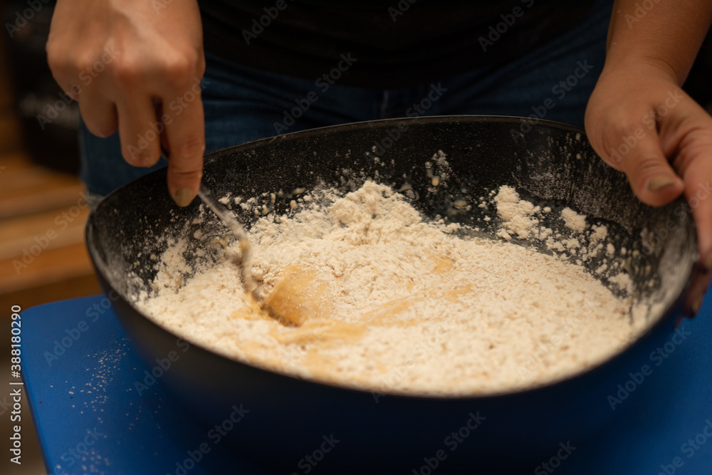 hands of a woman straining flour for a cake hands of a woman straining flour for a cake