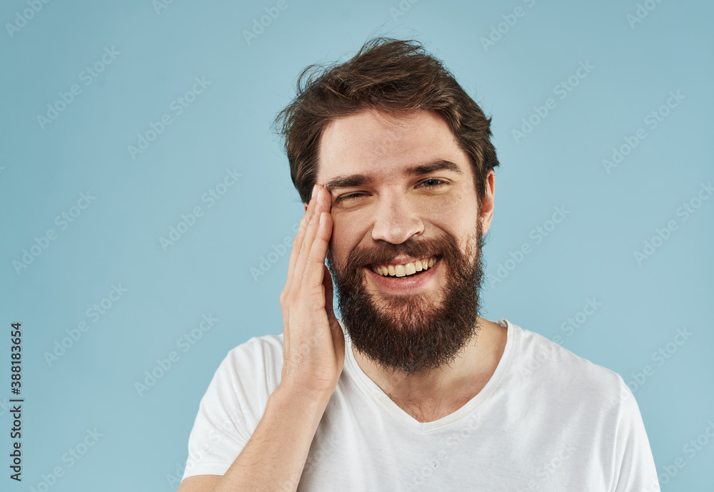 Handsome man with a beard on a blue background white t-shirt portrait Handsome man with a beard on a blue background white t-shirt portrait