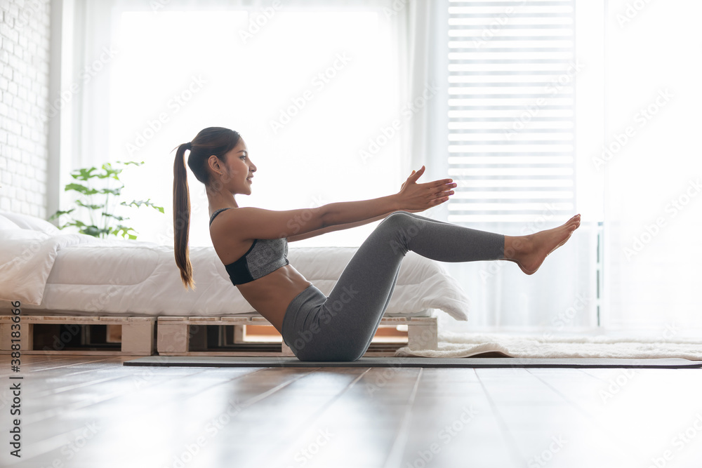 Attractive Asian indian woman practice yoga boat pose or Navasana pose to meditation in bedroom after wake up in the morning Feeling so comfortable and relax,Healthcare Concept Attractive Asian indian woman practice yoga boat pose or Navasana pose to meditation in bedroom after wake up in the morning Feeling so comfortable and relax,Healthcare Concept