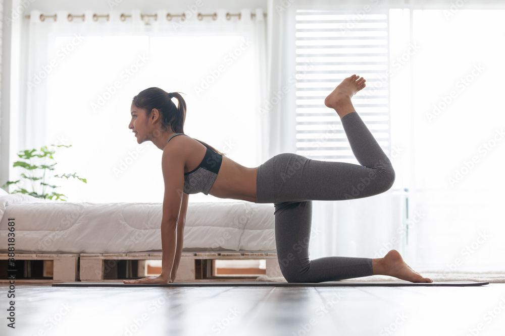 Athletic Healthy Asian indian woman in sportswear workout excercise at home in bedroom,Young woman with slim body cardio aerobic exercises healthy lifestyle concept - obrazy, fototapety, plakaty 