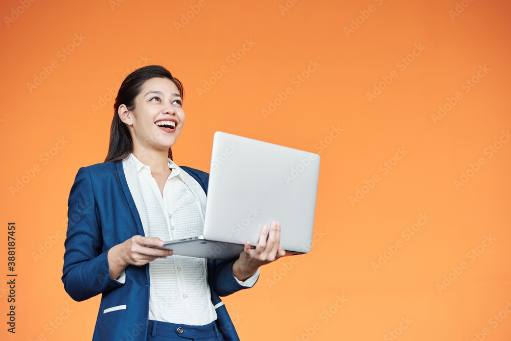 Happy excited young businesswoman holding opened laptop and smiling after receiving e-mail with good news Happy excited young businesswoman holding opened laptop and smiling after receiving e-mail with good news