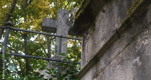 an old cross made of stone in the pere lachaise cemetary