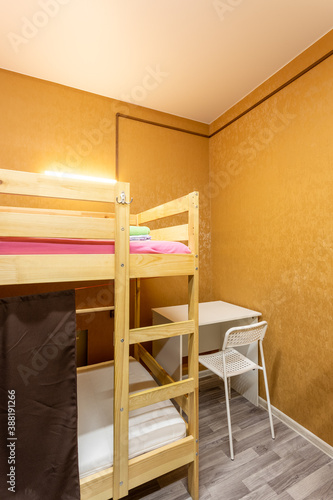 Konstfotografi Wooden bunk bed with curtains, desk and chair in large hostel dorm room