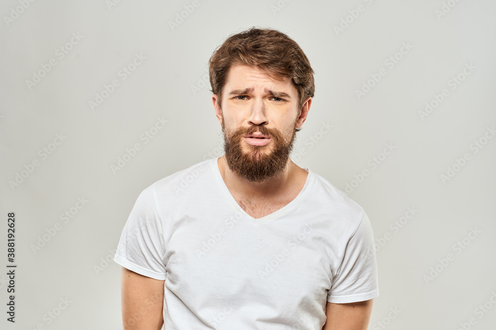 man in white t-shirt gesturing with his hands studio dissatisfaction lifestyle light background man in white t-shirt gesturing with his hands studio dissatisfaction lifestyle light background