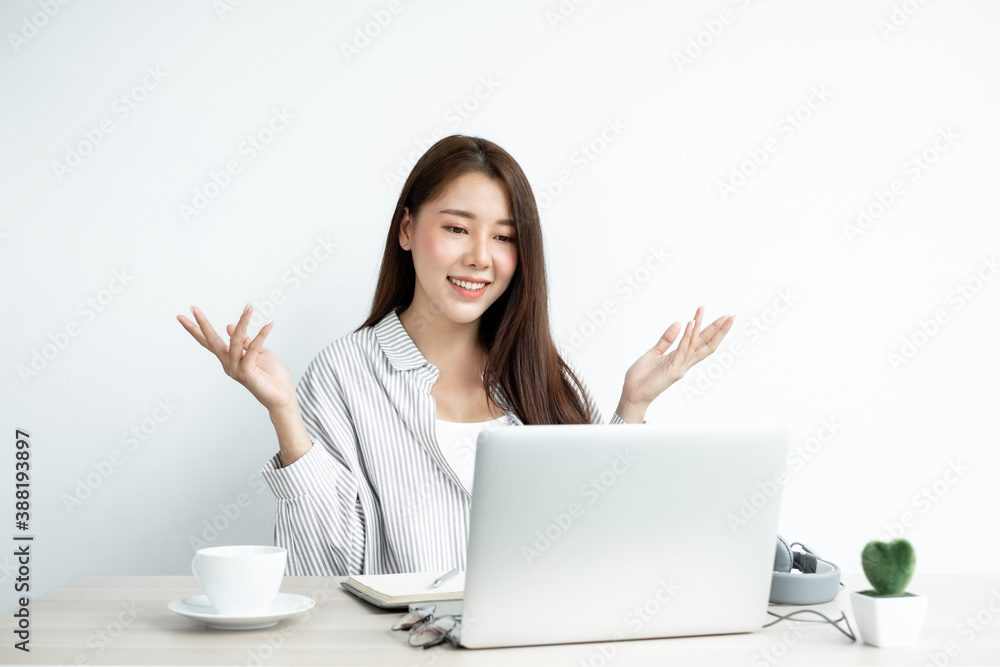 Video call, a young Asian woman communicates via online video long distance, looking at the digital laptop screen, happily greeted with a friend Video call, a young Asian woman communicates via online video long distance, looking at the digital laptop screen, happily greeted with a friend