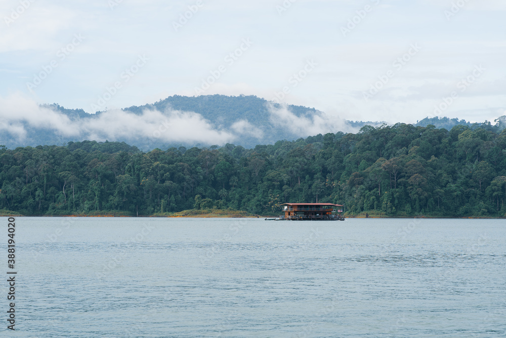 Houseboat cruising through the lake with mountain view at Kenyir Lake. Tasik Kenyir is a man made lake.