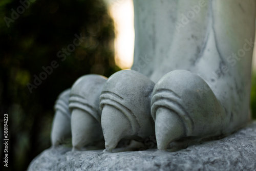 Fragment of paws and claws of a lion statue made of white marble