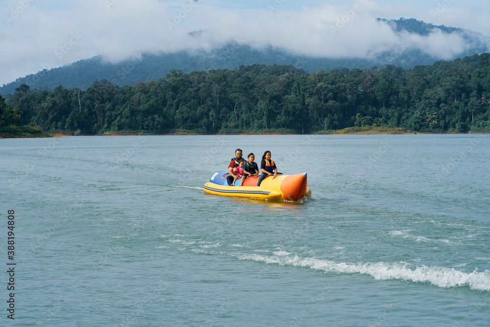 People enjoying water activities on banana boat at the Kenyir Lake, Terengganu, Malaysia.