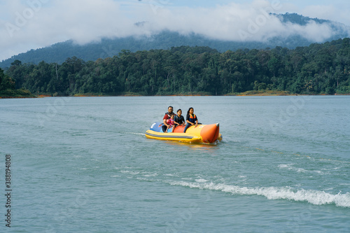 People enjoying water activities on banana boat at the Kenyir Lake, Terengganu, Malaysia. © ellinnur