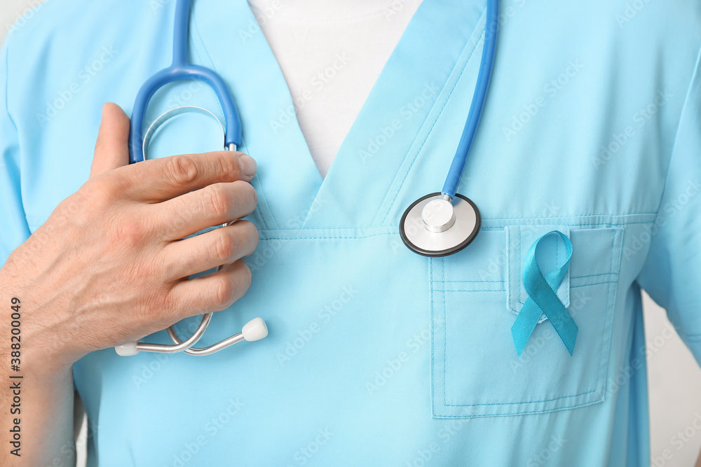 Male doctor with blue ribbon, closeup. Prostate cancer awareness concept Male doctor with blue ribbon, closeup. Prostate cancer awareness concept
