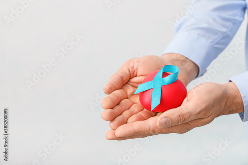 Wallpaper Mural Male hands with blue ribbon and heart on light background. Prostate cancer awareness concept Torontodigital.ca