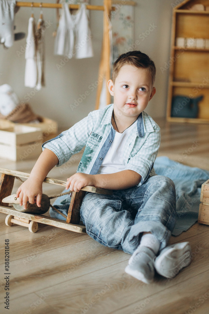 Cute boy playing with wooden airplane at home Cute boy playing with wooden airplane at home