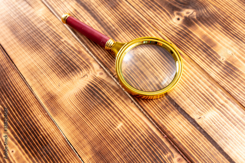 Close-up of a magnifier on a wooden background.