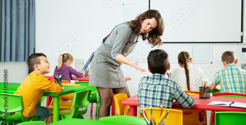 Obraz na płótnie Female teacher scolding guilty student in elementary school class