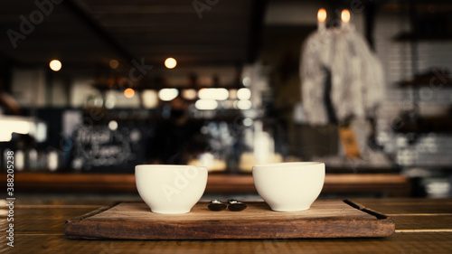 Portrait of two coffee cups freshly made and steaming on boards in trendy cafe