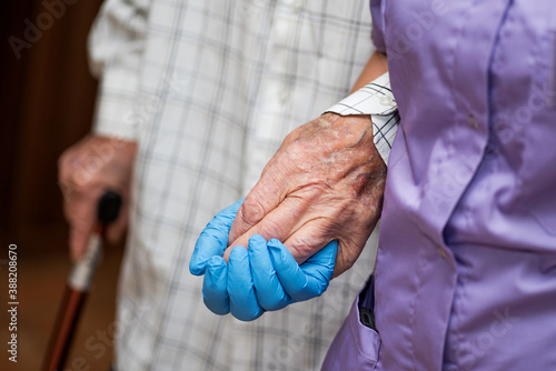 Doctor holding elderly patient's hands with care.