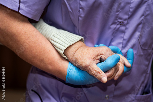 Doctor holding elderly patient's hands with care.