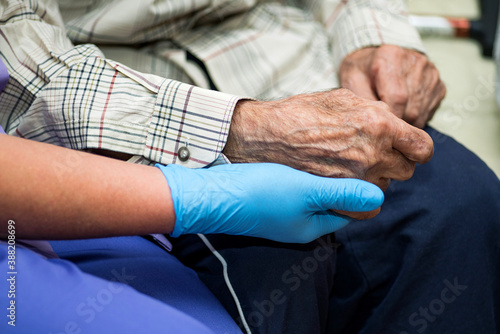 Doctor holding elderly patient's hands with care.