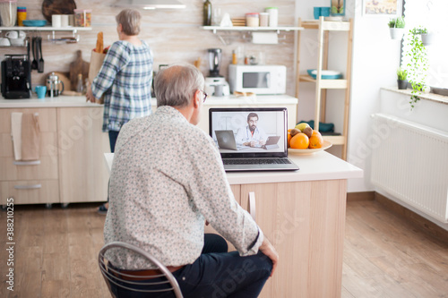 Senior couple having a video conference with doctor talking ill treatment. Online health consultation for elderly people drugs ilness advice on symptoms, physician telemedicine webcam. Medical care photo