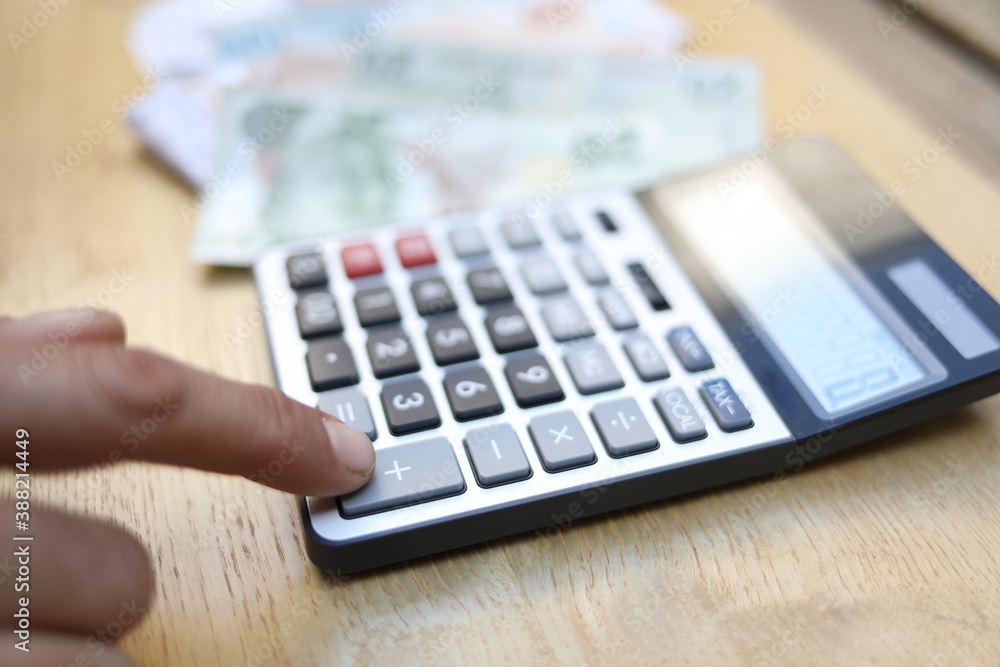man doing financial transactions with calculator holding money in hand. man doing financial transactions with calculator holding money in hand.