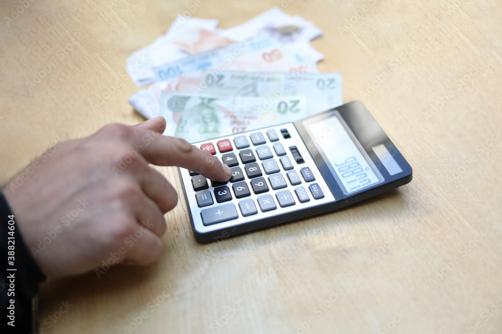 man doing financial transactions with calculator holding money in hand. man doing financial transactions with calculator holding money in hand.