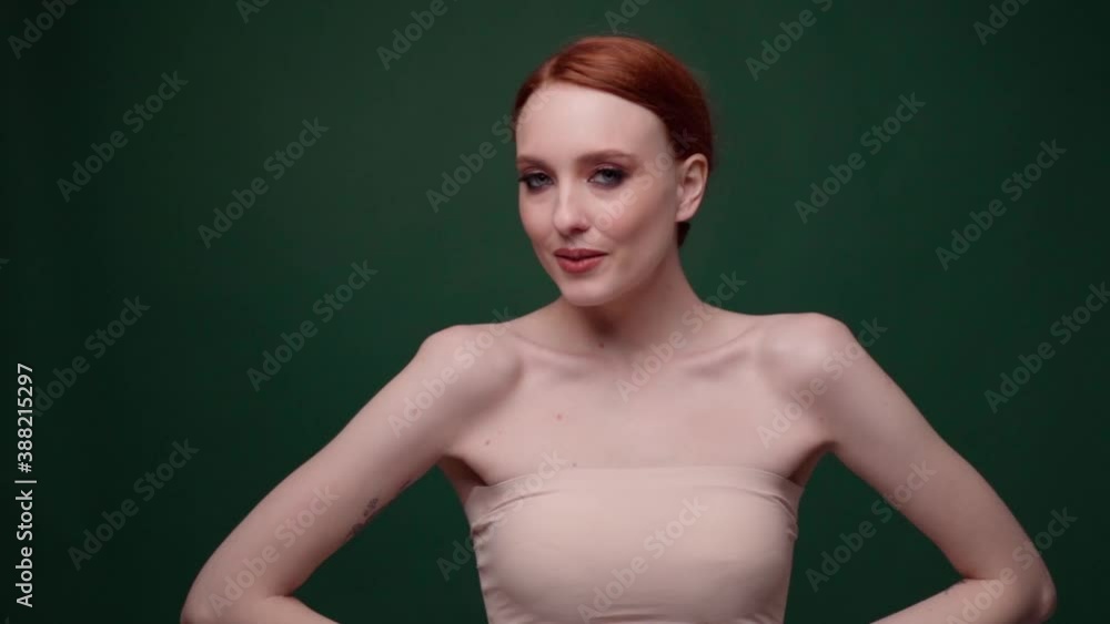 Beautiful fashionable girl with long curly red hair. Girl in the studio on a green background. Advertising, hair products, beauty salon, cosmetics, clothing. Fashion, boutique. Beautiful fashionable girl with long curly red hair. Girl in the studio on a green background. Advertising, hair products, beauty salon, cosmetics, clothing. Fashion, boutique.