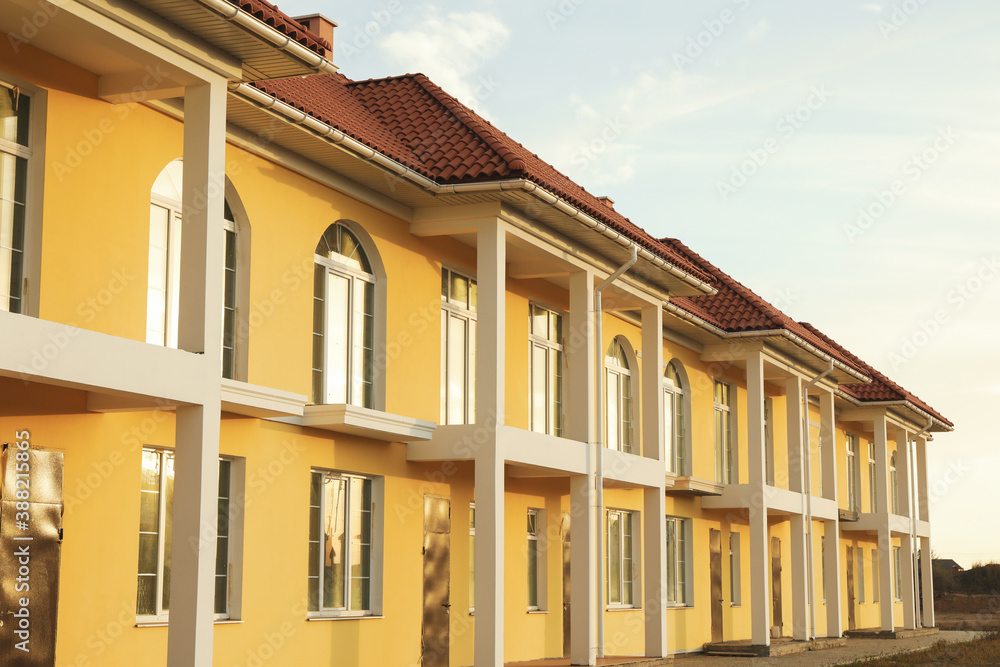 Beautiful new yellow townhouses with red - brown roof Beautiful new yellow townhouses with red - brown roof